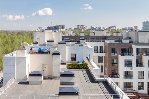 Flat roofing in Westwego, LA, with air conditioning units on top of a modern apartment building.
